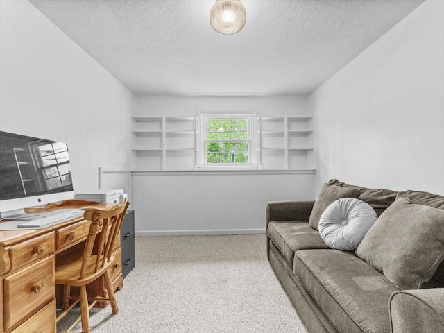 office area with carpet flooring, a textured ceiling, and baseboards