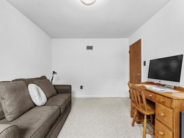 carpeted home office with a textured ceiling and baseboards