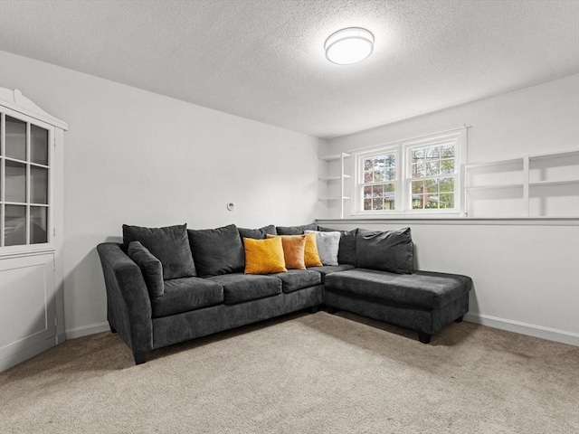 carpeted living area with a textured ceiling and baseboards