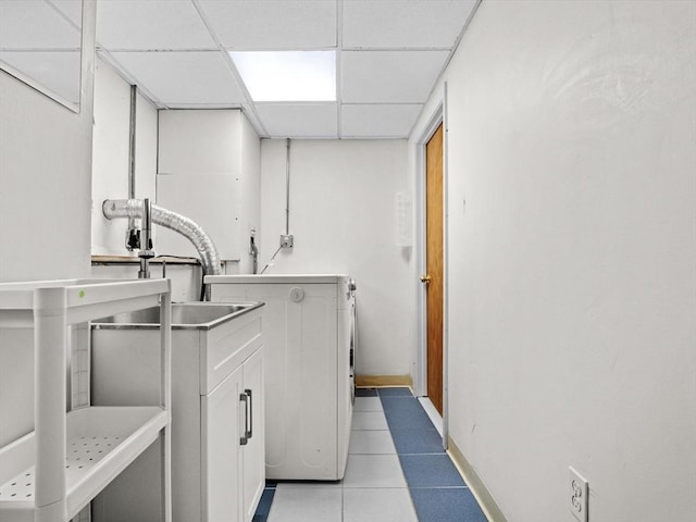 laundry room featuring washer / clothes dryer, light tile patterned floors, and baseboards