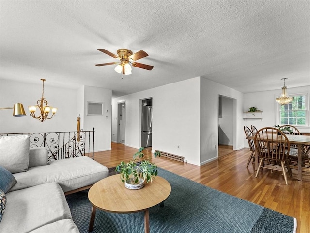 living room with a chandelier, wood finished floors, ceiling fan, a textured ceiling, and baseboards