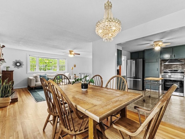 dining space with ceiling fan, light wood-style floors, and a chandelier