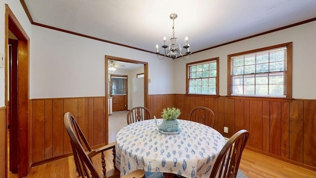 40 Revere St, Gloucester, MA 01930 - dining area with wainscoting, wood walls, a chandelier, light wood finished floors, and crown molding