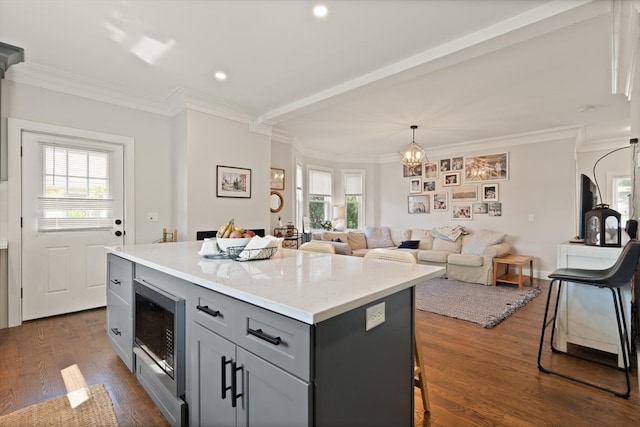 kitchen featuring a kitchen bar, a center island, plenty of natural light, and dark hardwood / wood-style flooring