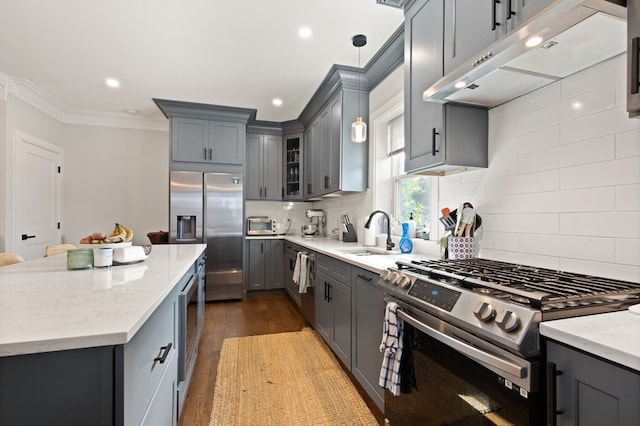 kitchen featuring appliances with stainless steel finishes, dark wood-type flooring, gray cabinets, and tasteful backsplash