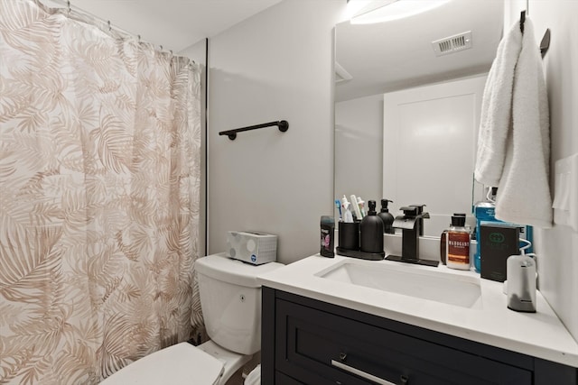 bathroom with walk in shower, vanity, and toilet