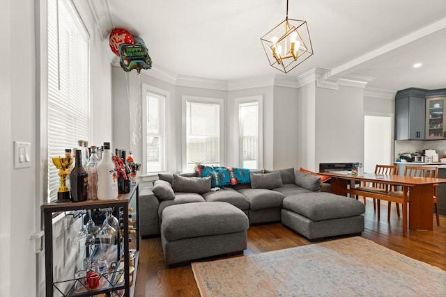 living room with an inviting chandelier, crown molding, and dark hardwood / wood-style flooring