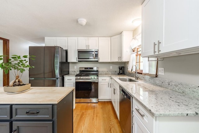 53 Greenleaf Dr, Hampden, MA 01036 - kitchen with stainless steel appliances, a sink, gray cabinetry, white cabinets, and light wood-type flooring