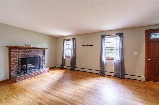 53 Greenleaf Dr, Hampden, MA 01036 - unfurnished living room with light wood-style floors, plenty of natural light, a brick fireplace, and baseboards
