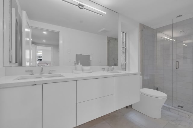 bathroom with tile flooring, double vanity, a shower with door, and toilet