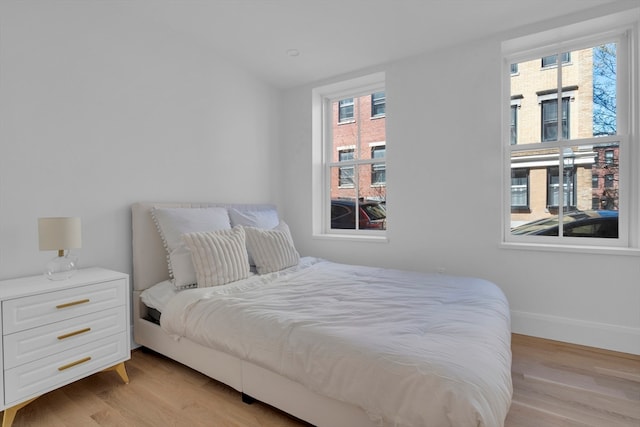 bedroom featuring light wood-type flooring and multiple windows