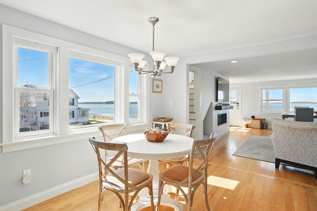 119 Fort Point Rd, Weymouth, MA 02191 - dining room featuring a chandelier, light wood-style floors, baseboards, recessed lighting, and a glass covered fireplace