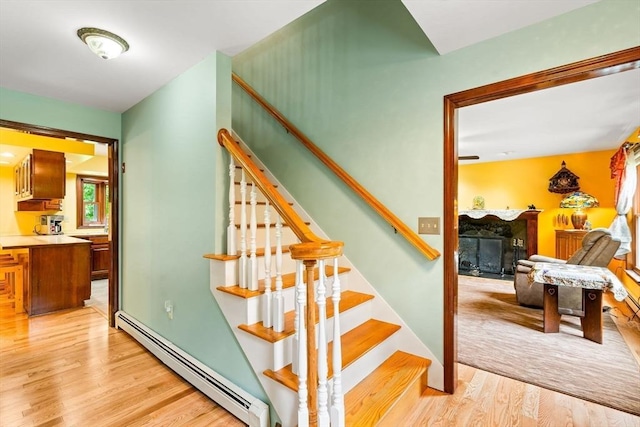 906 Clark St, Gardner, MA 01440 - stairs with a baseboard heating unit, a fireplace, and wood finished floors