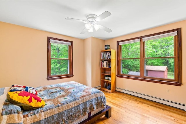 906 Clark St, Gardner, MA 01440 - bedroom featuring a baseboard radiator, light wood-style flooring, and a ceiling fan