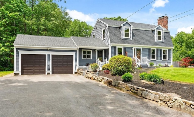 906 Clark St, Gardner, MA 01440 - colonial inspired home featuring a garage, driveway, a gambrel roof, a chimney, and a front lawn
