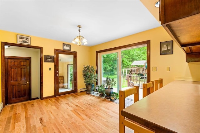 906 Clark St, Gardner, MA 01440 - dining area with light wood-style floors, a chandelier, a baseboard heating unit, and baseboards