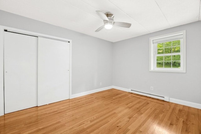 153 Milk St Unit 4, Westborough, MA 01581 - unfurnished bedroom featuring a baseboard radiator, wood finished floors, a closet, and baseboards
