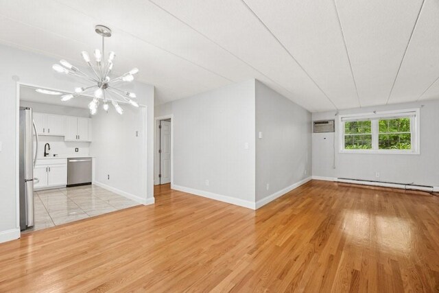 153 Milk St Unit 4, Westborough, MA 01581 - unfurnished living room featuring a sink, a chandelier, a baseboard heating unit, light wood-style floors, and baseboards