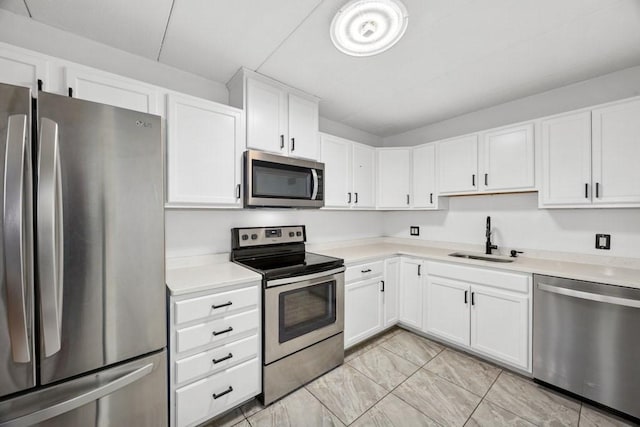 153 Milk St Unit 4, Westborough, MA 01581 - kitchen featuring appliances with stainless steel finishes, a sink, light countertops, and white cabinetry