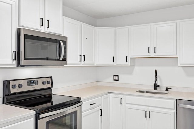 153 Milk St Unit 4, Westborough, MA 01581 - kitchen with appliances with stainless steel finishes, a sink, white cabinetry, and light countertops