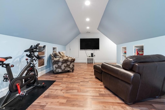 exercise area with built in shelves, lofted ceiling, and light hardwood / wood-style floors