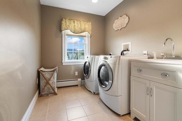 washroom featuring light tile patterned flooring, sink, cabinets, a baseboard heating unit, and independent washer and dryer