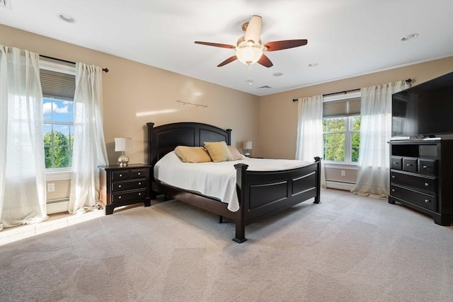 bedroom with a baseboard radiator, light colored carpet, and ceiling fan