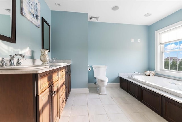 bathroom featuring tile patterned flooring, vanity, a tub, and toilet