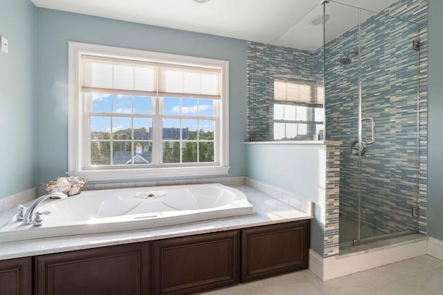 bathroom with tile patterned flooring, shower with separate bathtub, and a healthy amount of sunlight