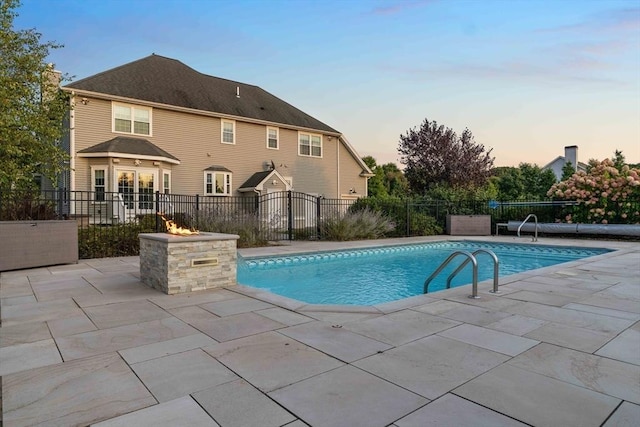 pool at dusk with a patio area