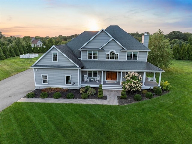 view of front of home with a porch and a yard