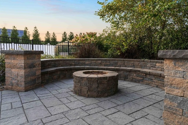 patio terrace at dusk featuring a fire pit