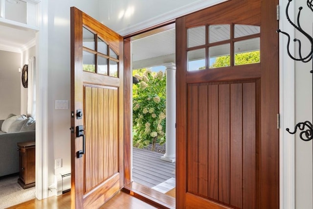 doorway to outside featuring a baseboard radiator, light hardwood / wood-style floors, and ornate columns