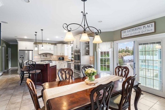 dining space featuring crown molding, sink, and light tile patterned flooring