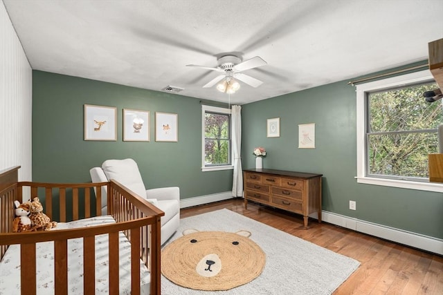bedroom featuring baseboards, multiple windows, and wood finished floors