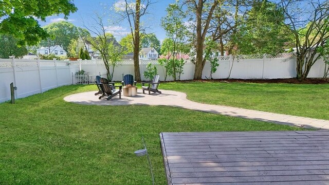 view of yard featuring a deck, a fire pit, and a patio area