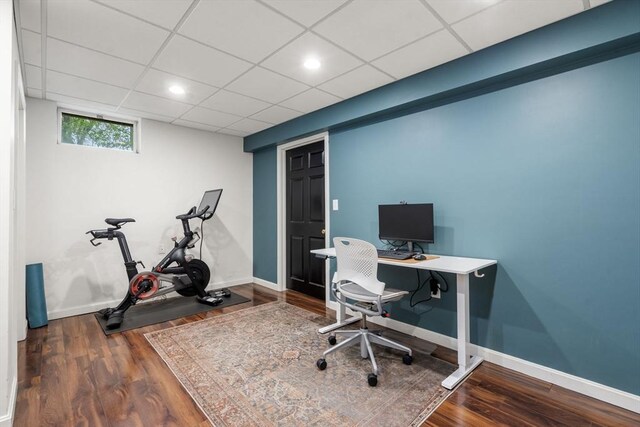 office space with wood finished floors, baseboards, and a drop ceiling