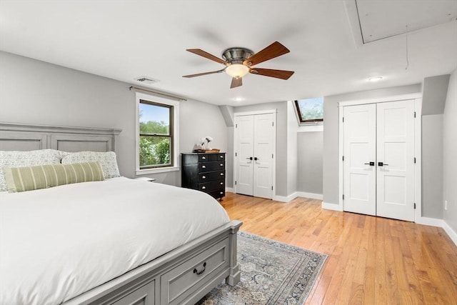 bedroom featuring attic access, multiple closets, light wood-style floors, baseboards, and recessed lighting