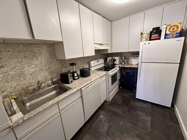 kitchen featuring tasteful backsplash, under cabinet range hood, white appliances, white cabinetry, and a sink