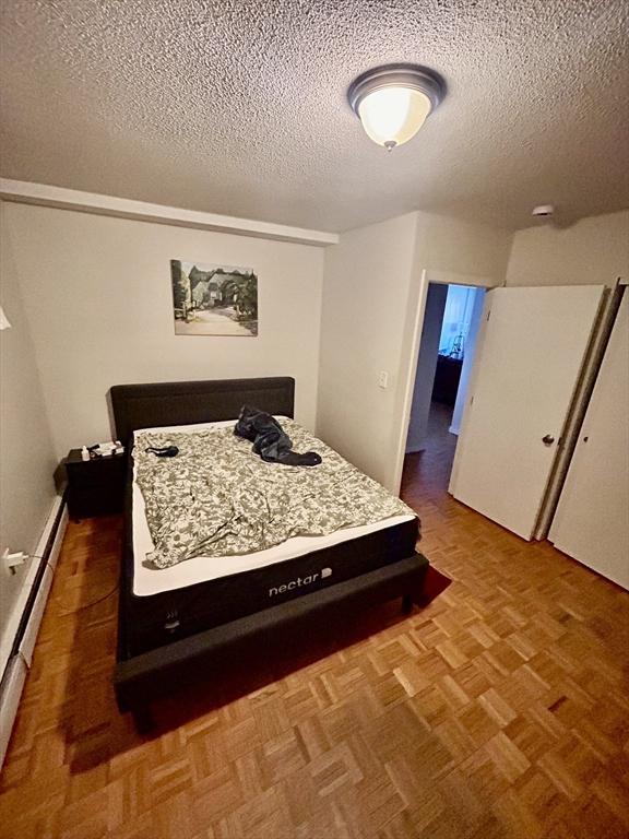 bedroom featuring a baseboard radiator and a textured ceiling