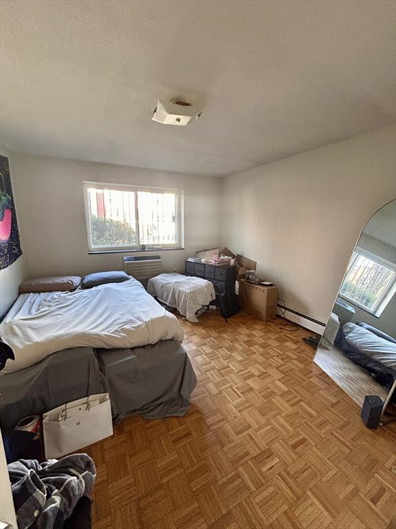 bedroom with a baseboard radiator and a textured ceiling