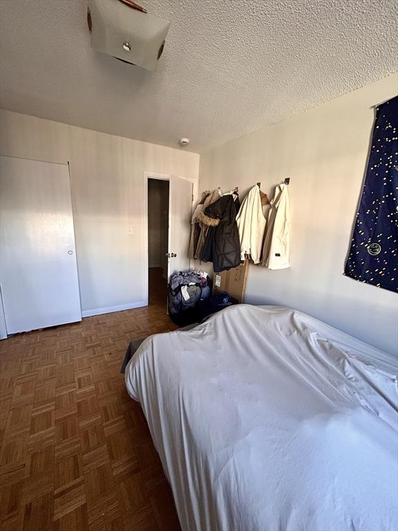 bedroom featuring a textured ceiling and baseboards