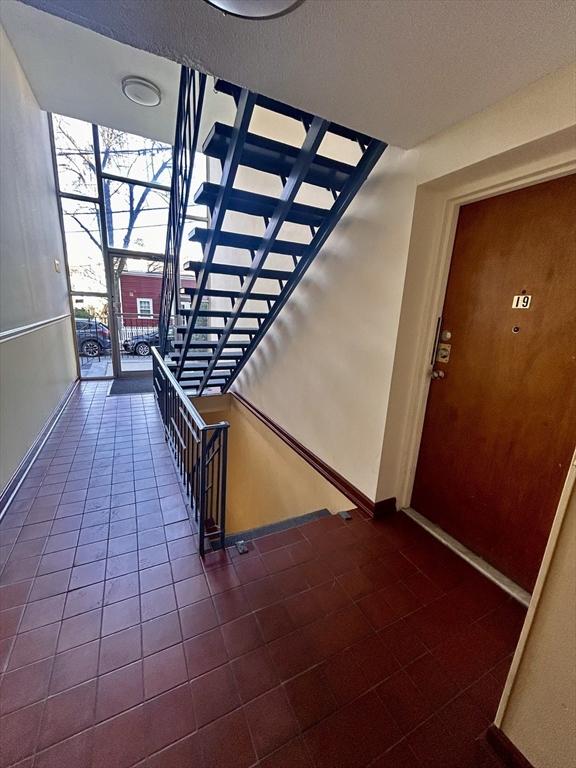 staircase with baseboards and tile patterned flooring