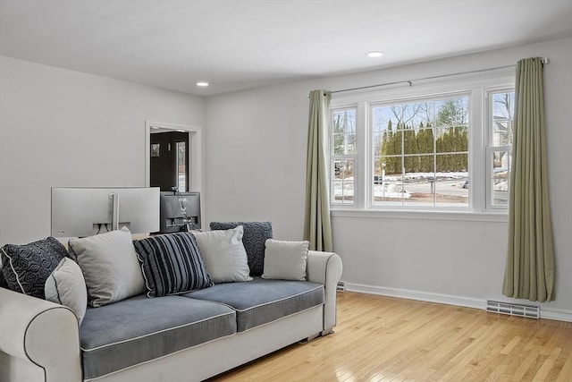 living area featuring light wood-type flooring, visible vents, baseboards, and recessed lighting