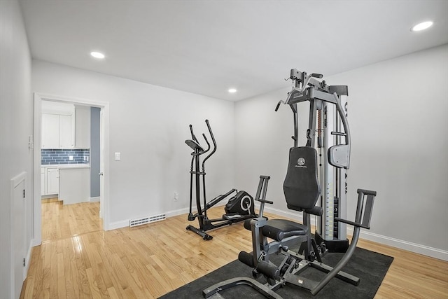 workout area featuring baseboards, recessed lighting, visible vents, and light wood-style floors