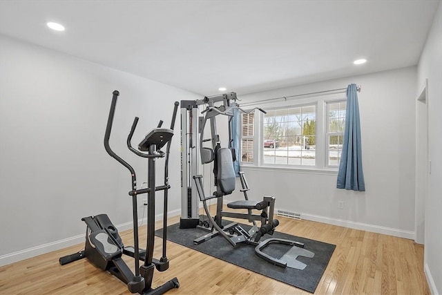 workout area featuring recessed lighting, light wood-style flooring, and baseboards