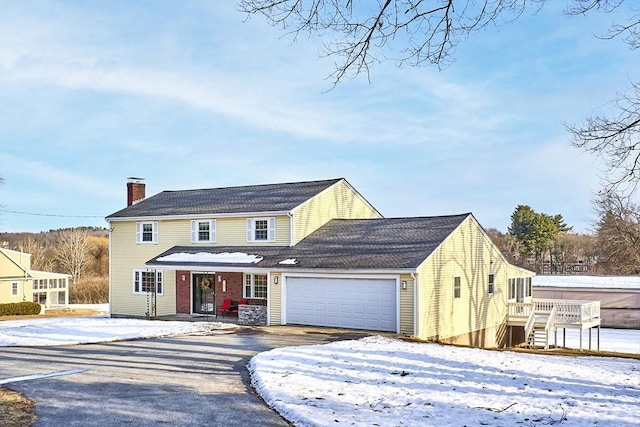 view of front facade with a chimney and an attached garage