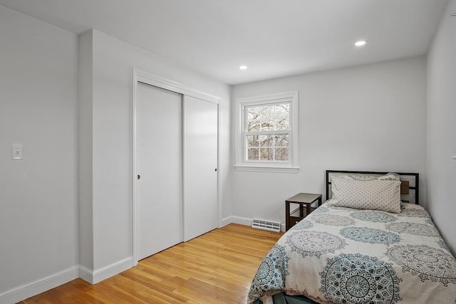 bedroom with recessed lighting, a closet, and wood finished floors