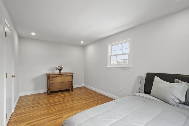 bedroom with baseboards, recessed lighting, and light wood-style floors