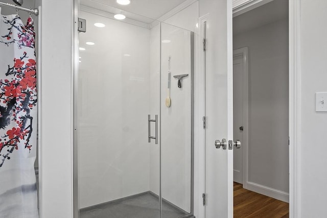 bathroom with a shower stall, baseboards, and wood finished floors